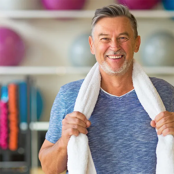 man in a blue shirt with a towel around his neck
