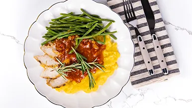 turkey breast over smoked cheddar grits with sweet pepper and tomato gravy and french green beans