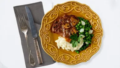 lentil salisbury steak over mashed potatoes with buttered peas and onions