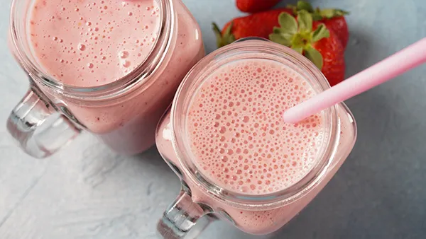2 strawberry smoothies in mason jars