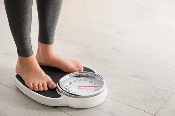 woman standing on a weight scale