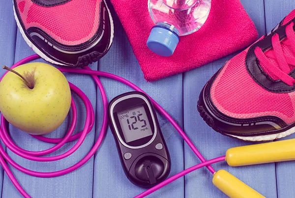 Shoes, water bottle, apple, jump rope and a glucose monitor