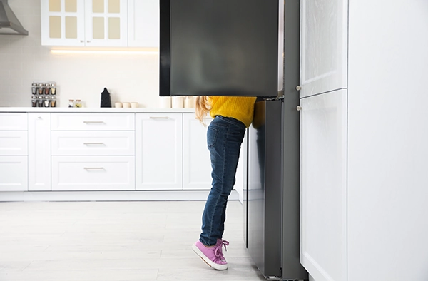 A child reaches into a refridgerator