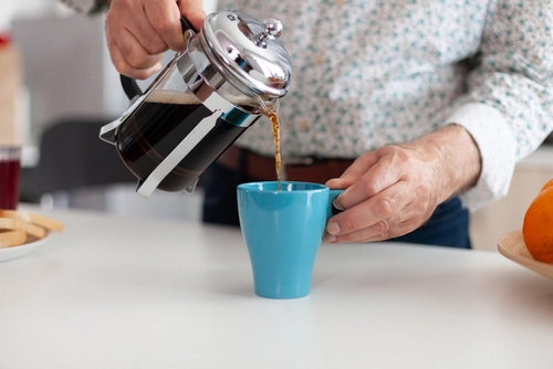 man pouring coffee from a french press