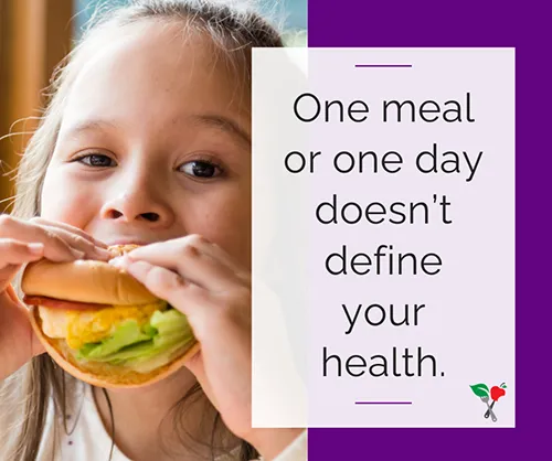 school aged girl eats a sandwich at lunch