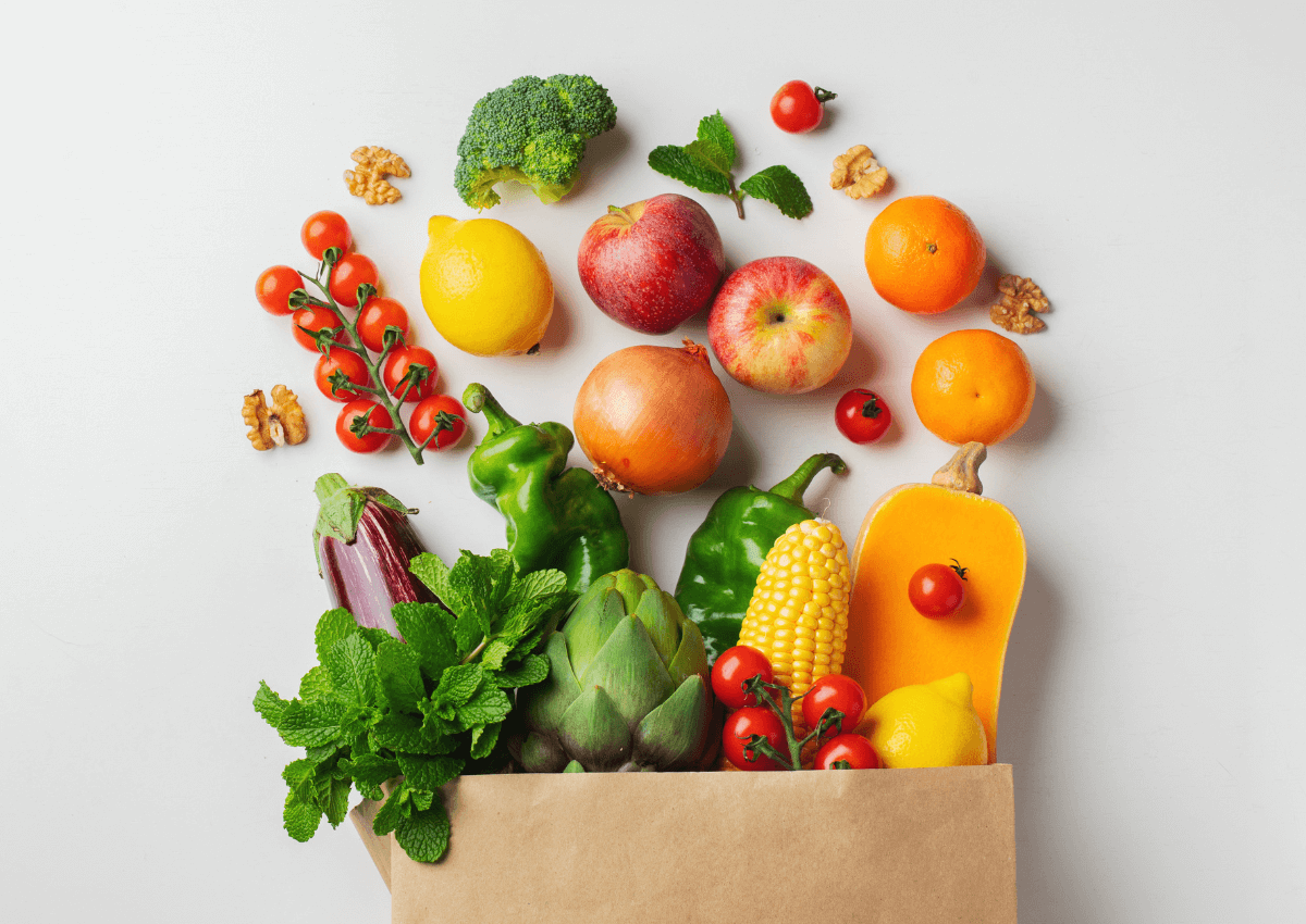 fruits and vegetables spilling out of brown paper bag