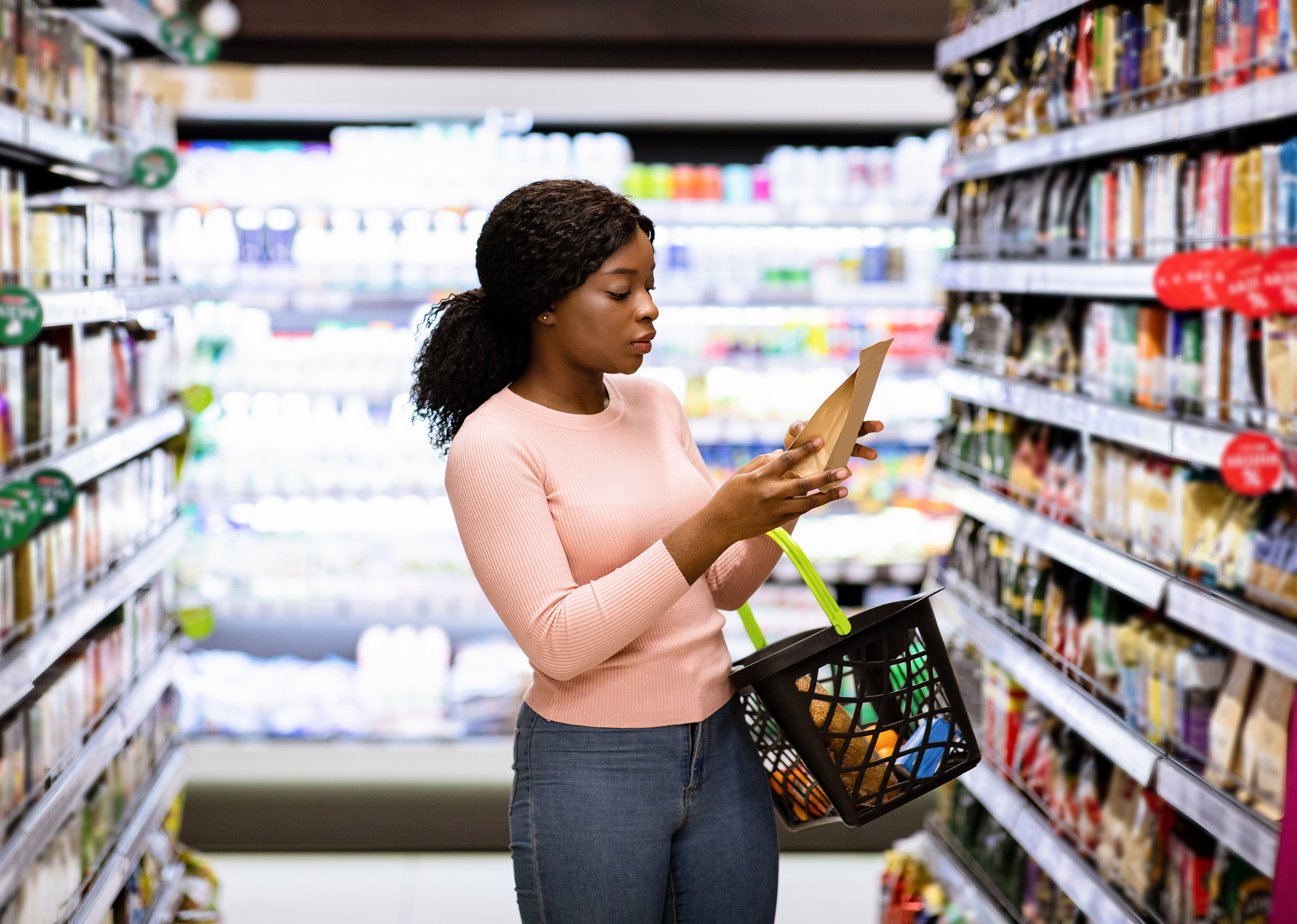 woman reading a food label at the grocery store